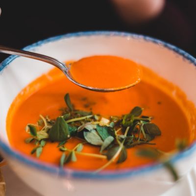 spoon of soup above bowl of soup