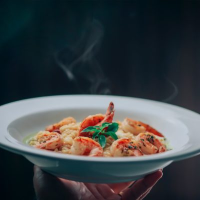 person holding white ceramic bowl with food